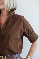 Brown shirt worn by a person on a plain background