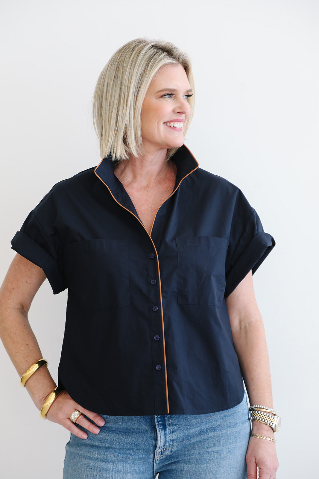 Woman wearing a navy blue blouse with a white background