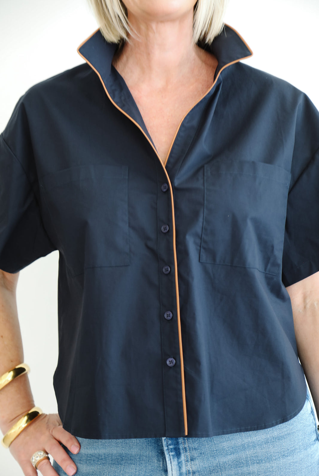 Person wearing a navy blue shirt with a white background