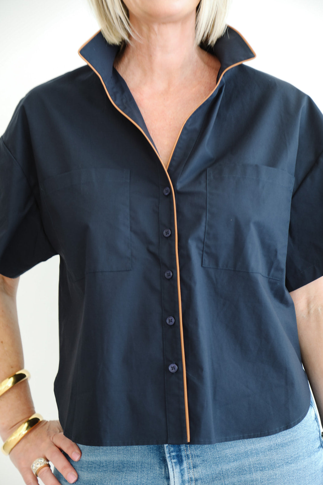 Person wearing a navy blue shirt with a white background