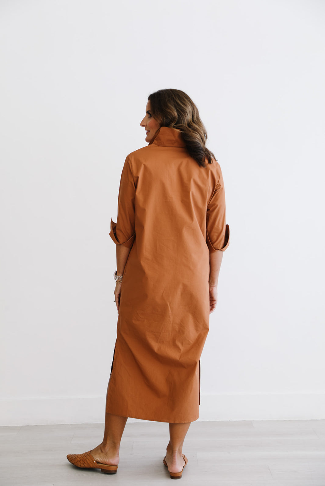 Woman wearing a brown dress against a white background