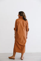 Woman wearing a brown dress against a white background