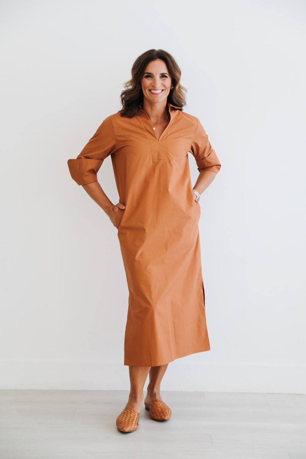 Woman wearing a brown dress against a white background