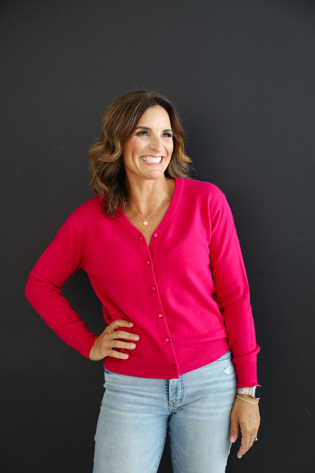 Woman wearing fuchsia pink 100% cashmere cardigan.