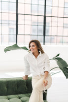 A white long sleeve button up shirt with a stand up ruffle collar and oversized cuffs.  Tied in a knot for a more casual look.
