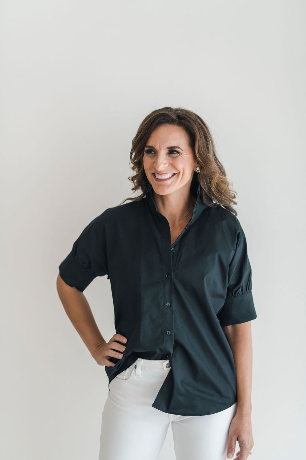 Crisp black button down shirt with a popped ruffle collar and short sleeves.