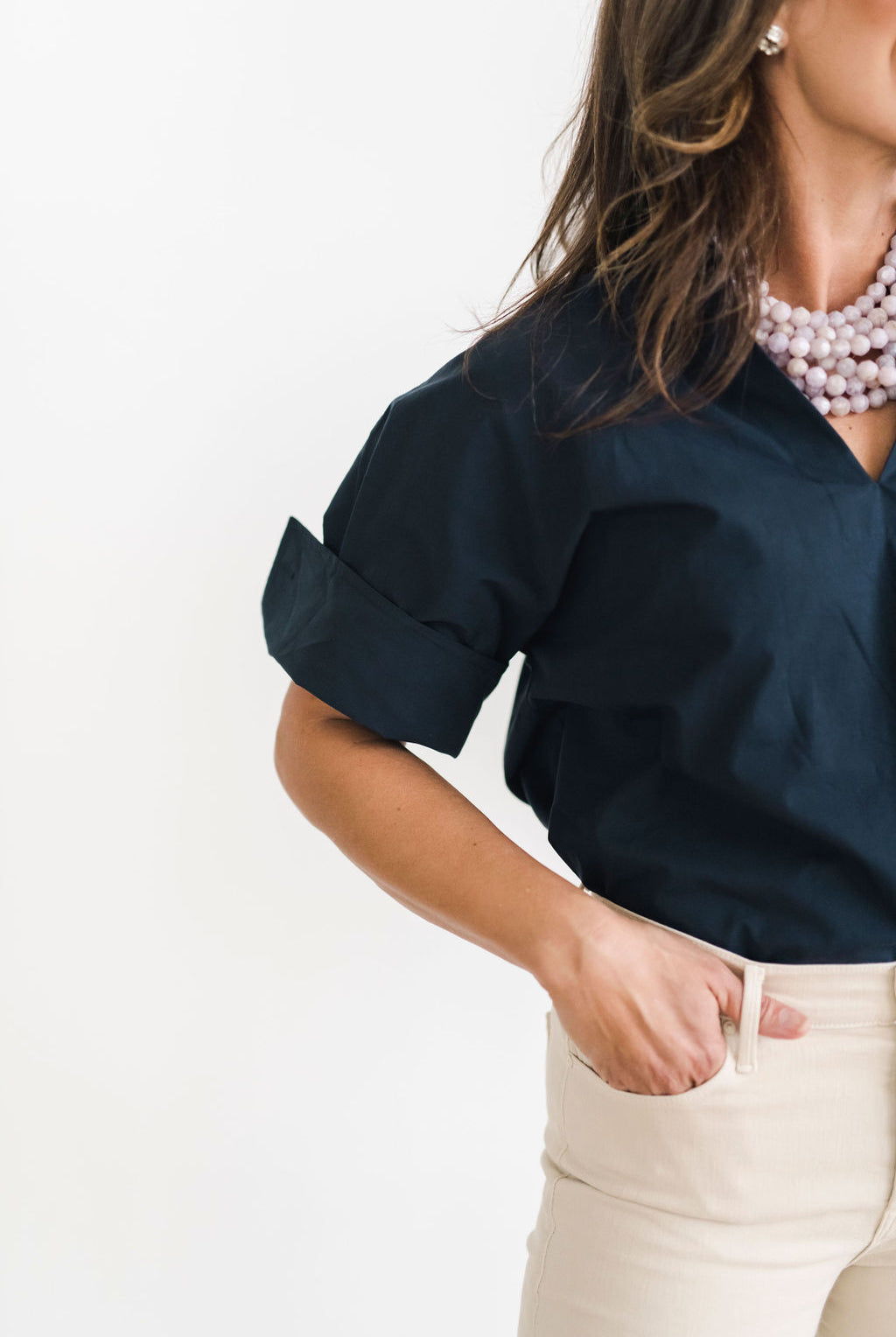 Navy blue cotton pullover style shirt with a stand up collar with a longer short sleeve with button details.