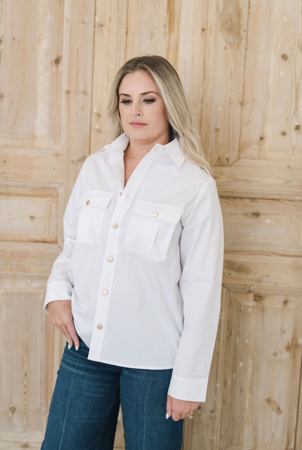 Women's white safari style button up shirt with gold buttons.