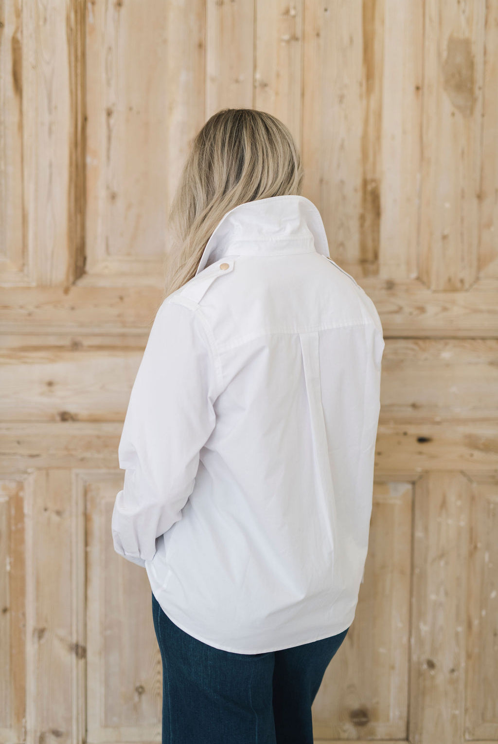 Women's white safari style button up shirt with gold buttons.
