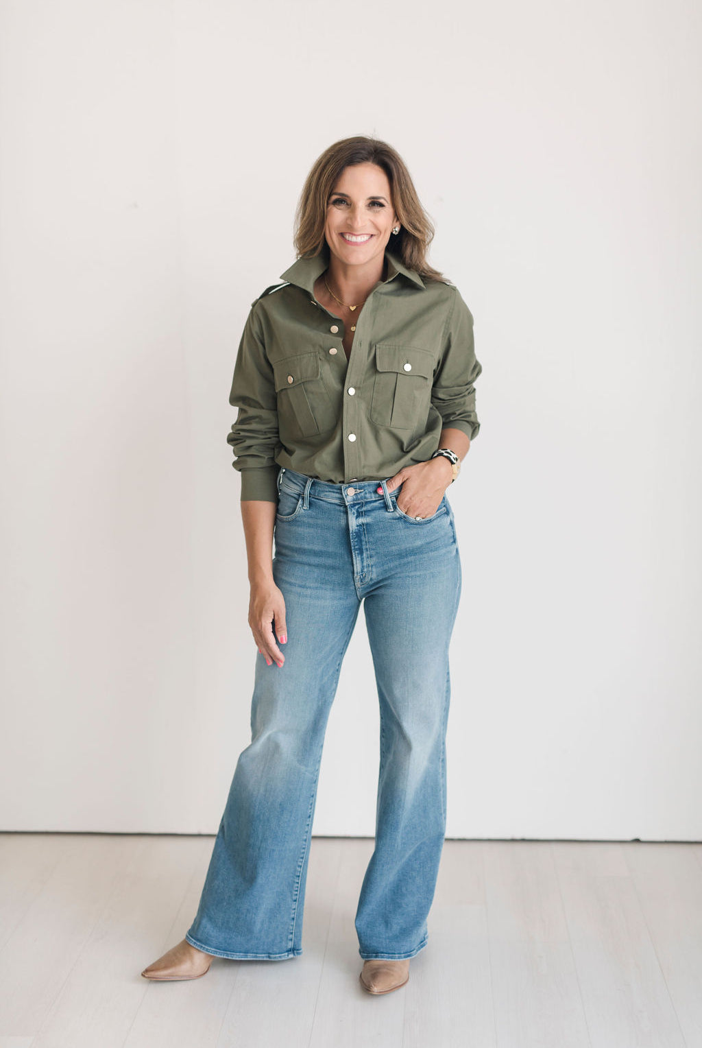 Women's olive green safari style button up shirt with gold buttons.