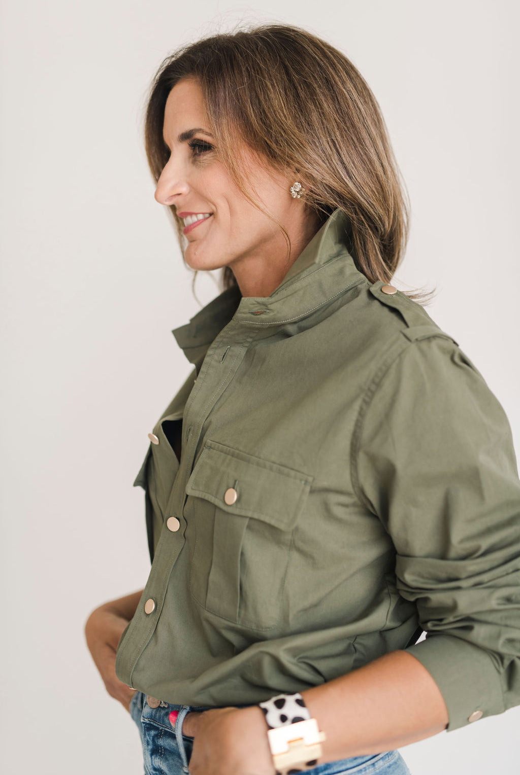Women's olive green safari style button up shirt with gold buttons.