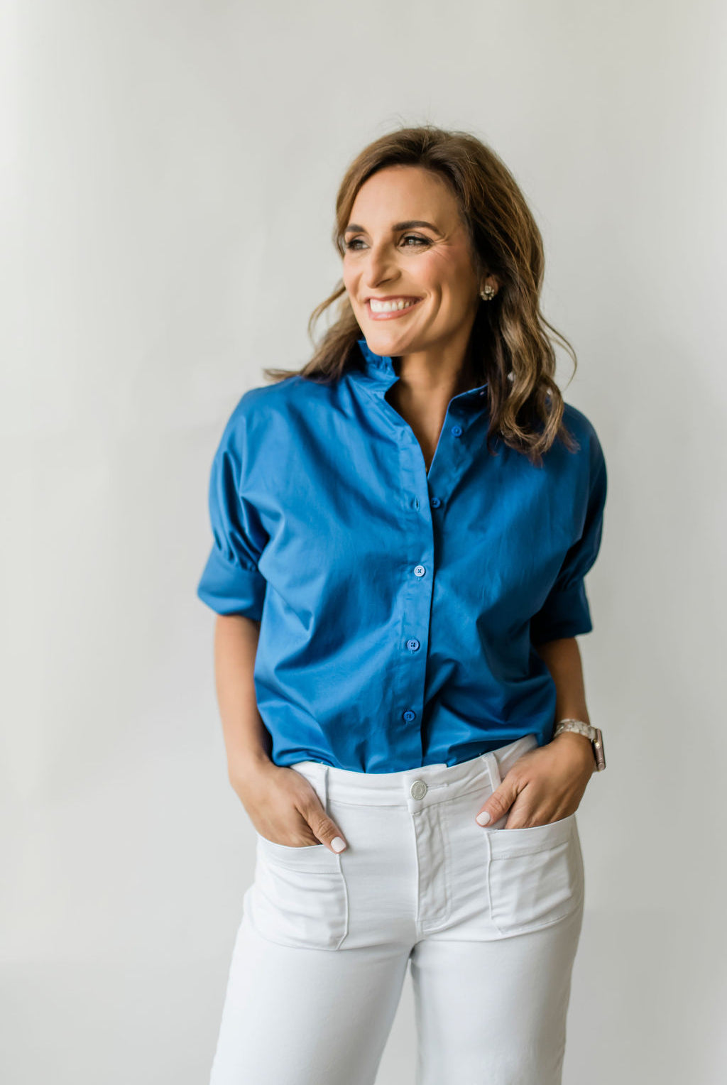 Crisp women's short sleeve button down shirt with a ruffle collar in bright blue.
