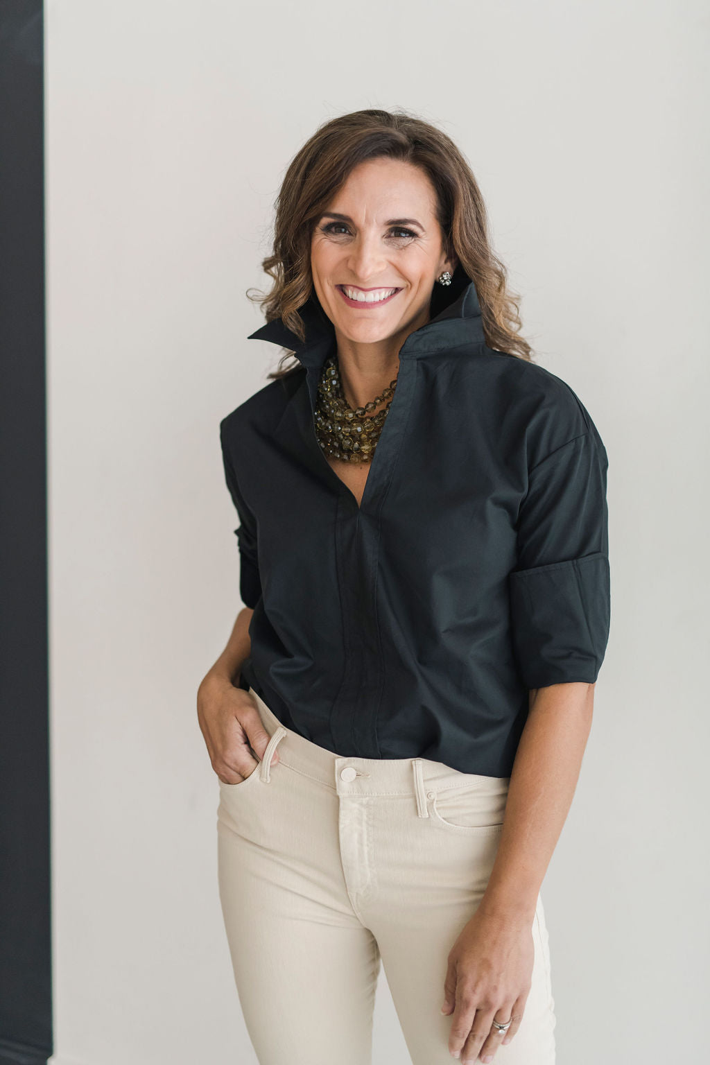 Black, crisp long sleeve shirt with a popped collar, pullover style.