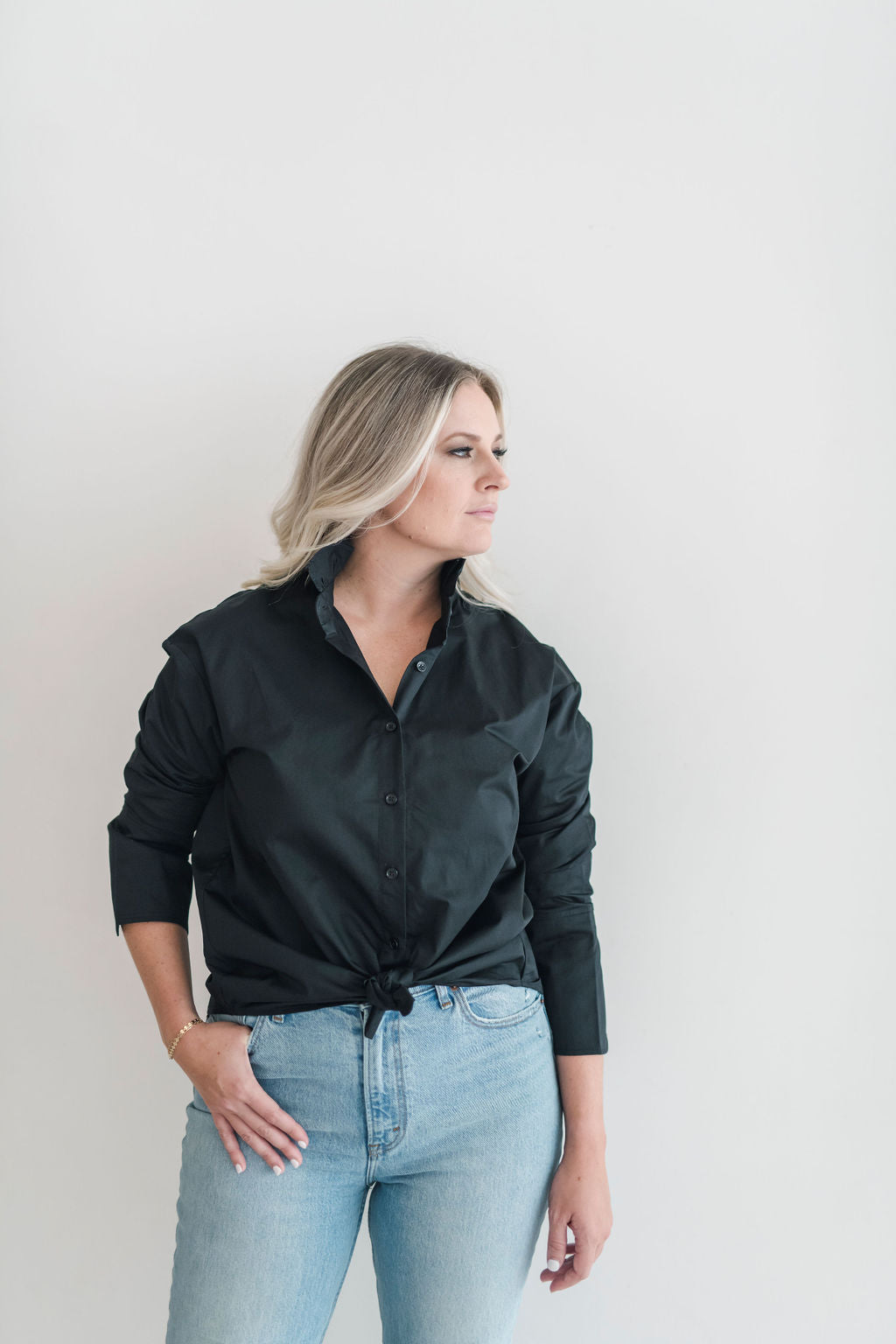 Black long sleeve button up shirt with a ruffle collar and large cuffs.  Tie in a knot, tuck it in or wea untucked for a more casual look.