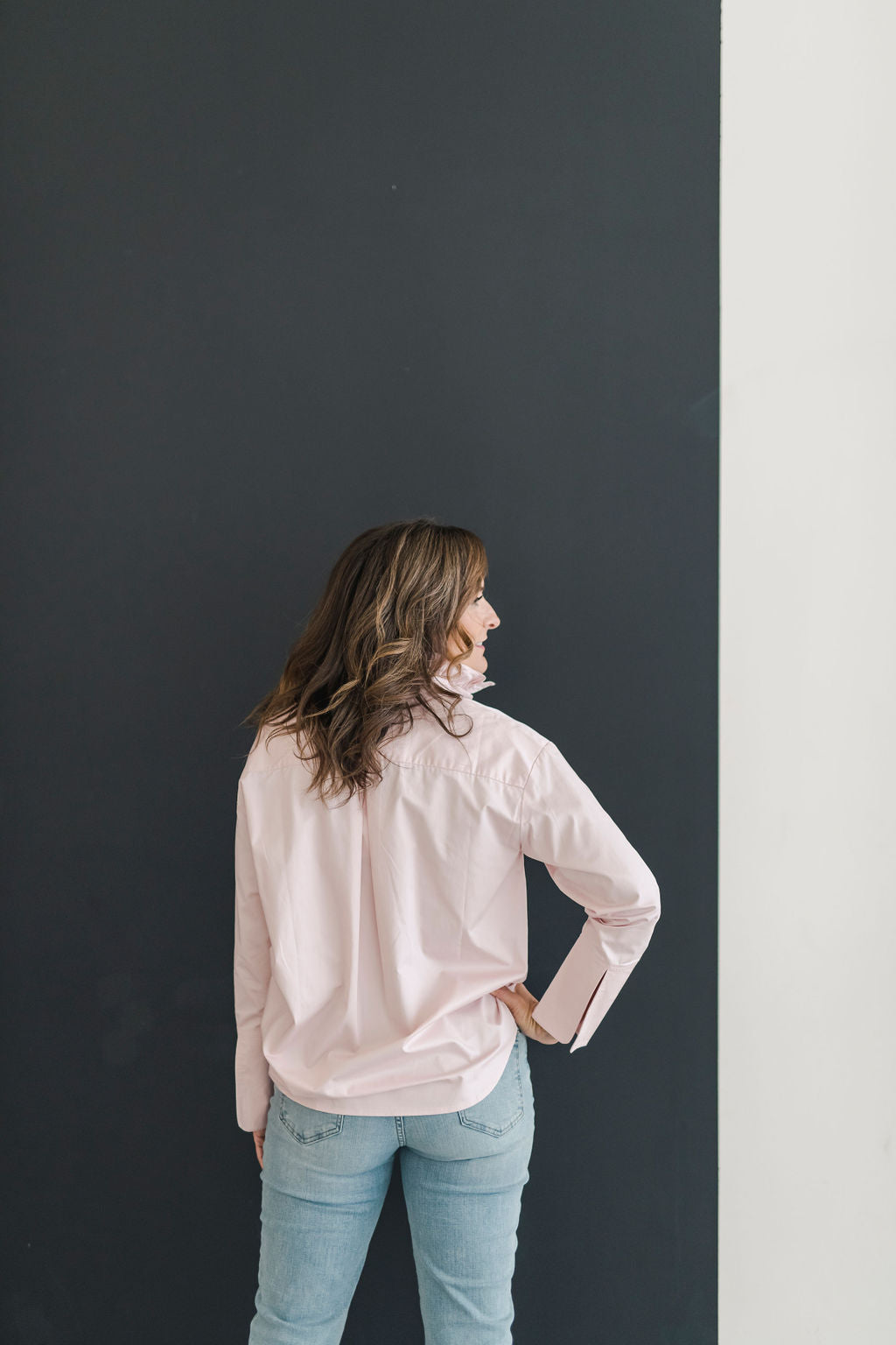 A button down shirt with a stand up ruffle collar in a beautiful blush color.  Has long sleeves and an oversized cuff.