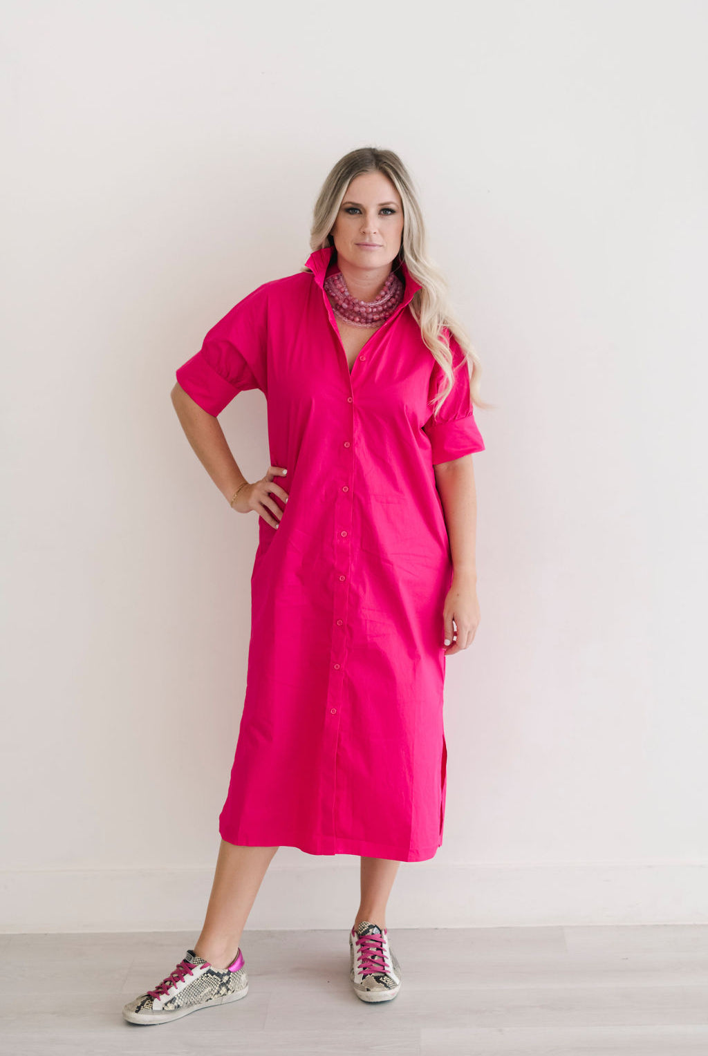 Button down shirt dress in hot pink.  Ruffle collar with elbow length sleeves.