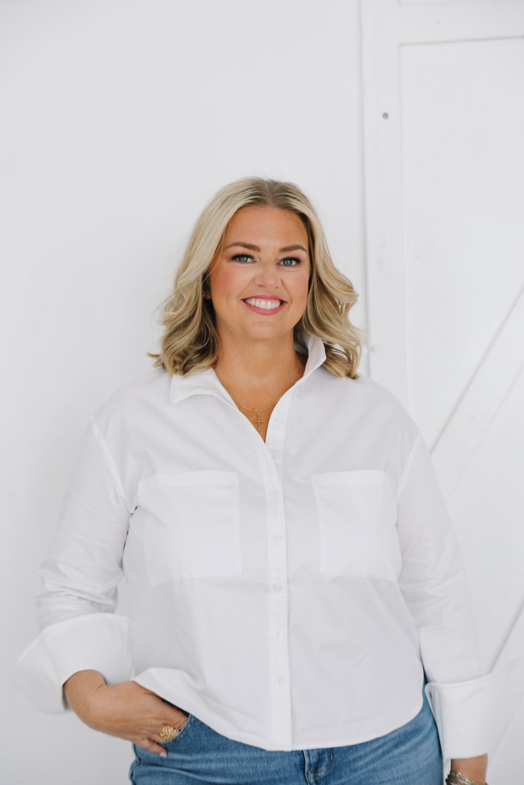 Woman wearing a white shirt and blue jeans against a white background
