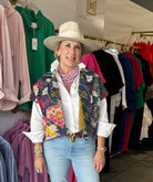 Ruffle collar button down shirt in white paired with  statement Jewlery and a hat.