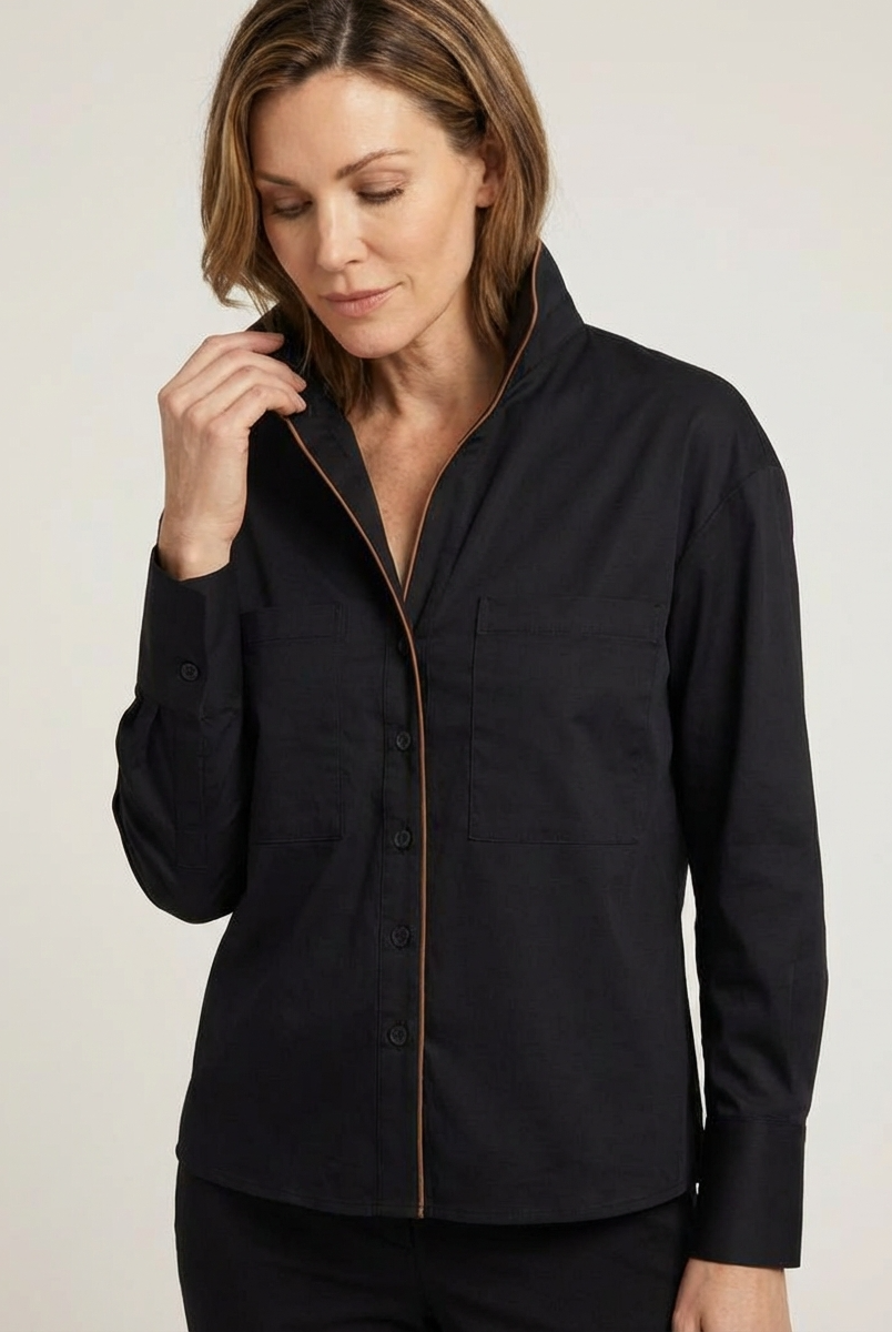 Woman wearing a black jacket with a zipper on a beige background