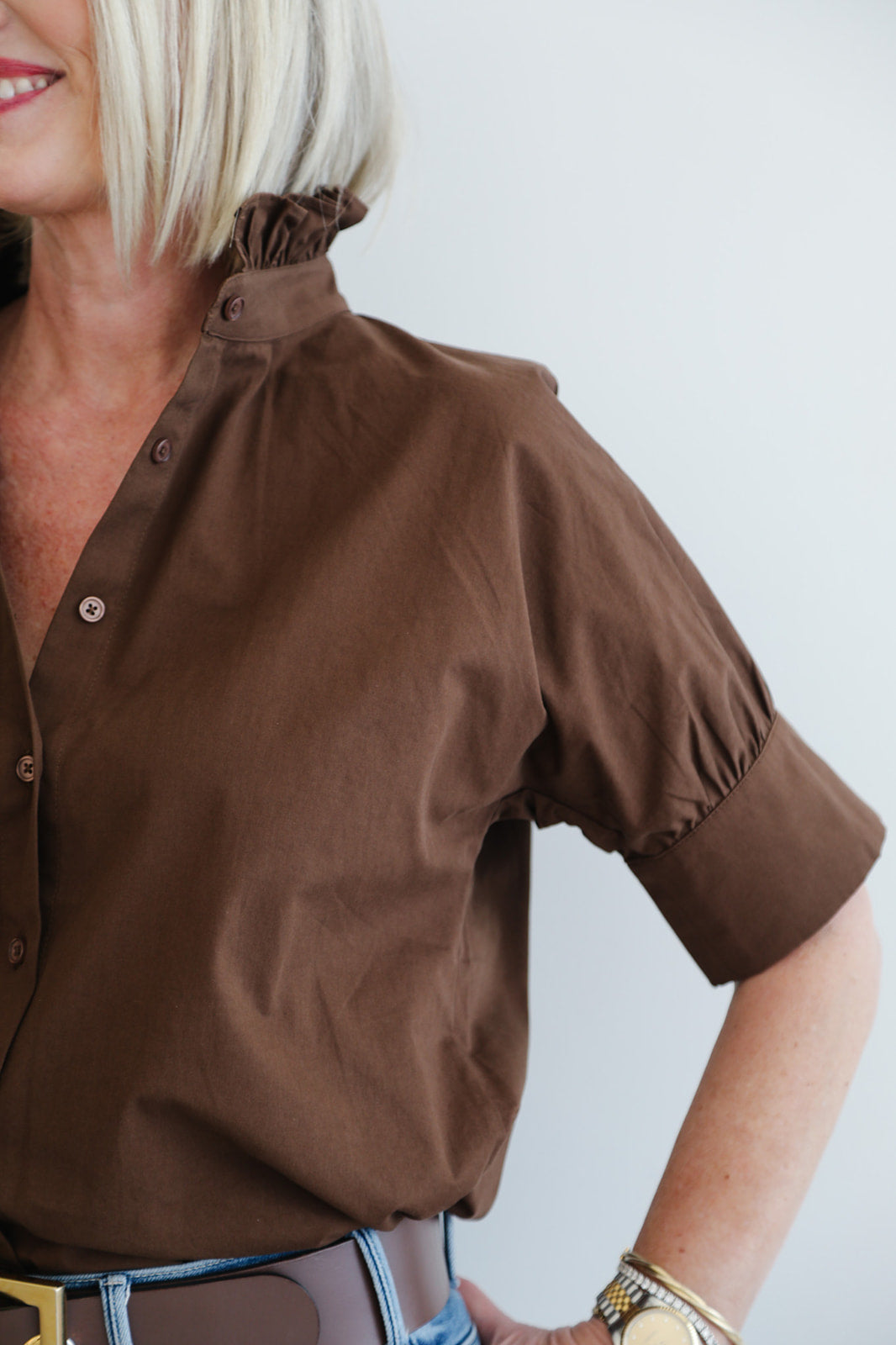 Brown shirt worn by a person on a plain background
