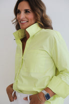 Woman wearing a bright yellow jacket against a white background