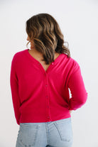 Woman wearing fuchsia pink 100% cashmere cardigan.
