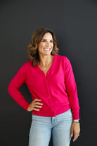 Woman wearing fuchsia pink 100% cashmere cardigan.