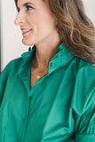 Green blouse with short sleeves and a ruffle collar.