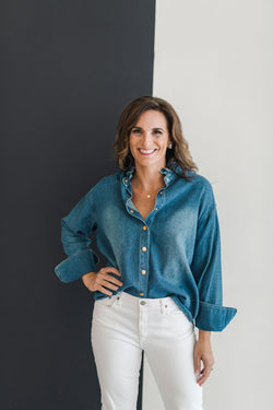 Long sleeve denim shirt with gold front snaps and a ruffle collar.