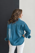 Long sleeve denim shirt with gold front snaps and a ruffle collar.