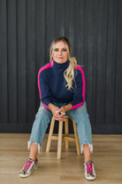 A cozy navy and pink colorblocked turtleneck sweater.