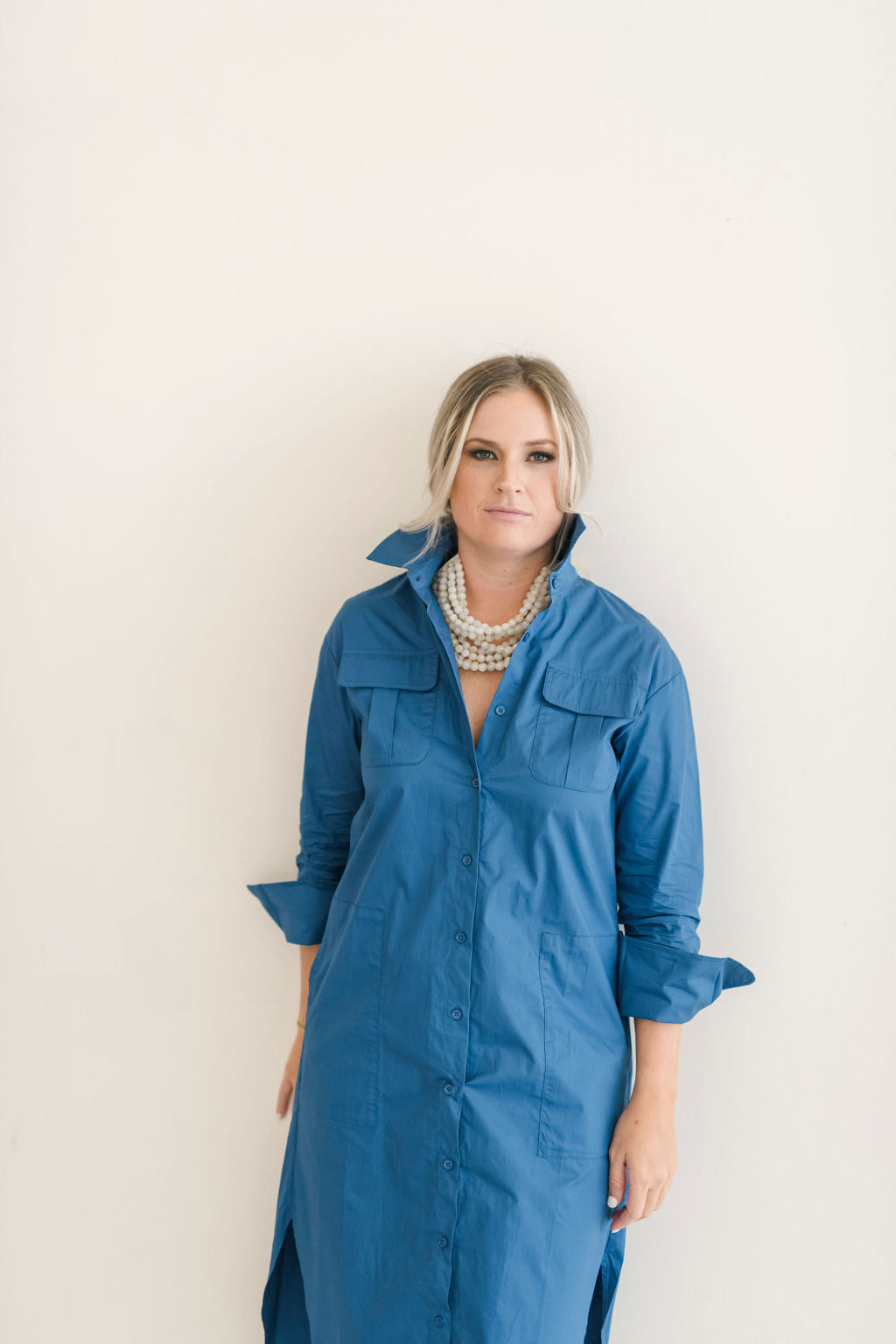 Button down shirt dress in a beautiful blue hue.  Features pockets and a popable collar.