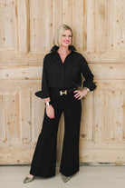 Crisp and classic women's button down shirt in black worn with trousers and heels for a dressed up look.