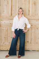 Crisp white women's button down shirt. Worn tied in a knot casually with jeans and jewlery.