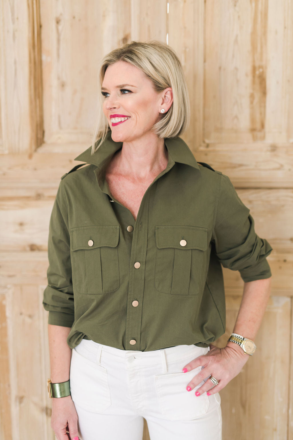 Women's olive green safari style button up shirt with gold buttons.