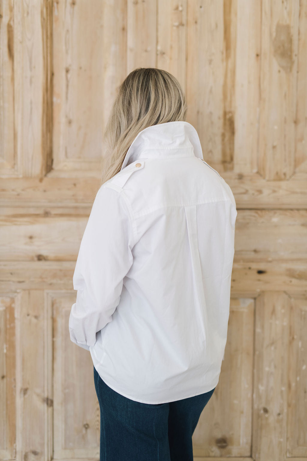 Women's white safari style button up shirt with gold buttons.