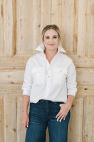 Women's white safari style button up shirt with gold buttons.