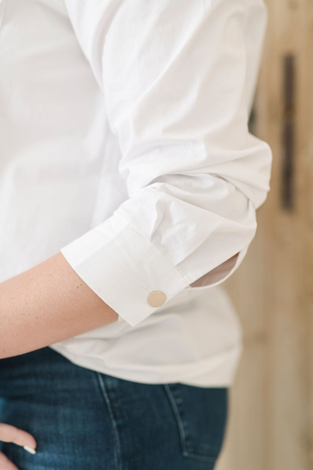 Women's white safari style button up shirt with gold buttons.