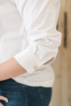 Women's white safari style button up shirt with gold buttons.