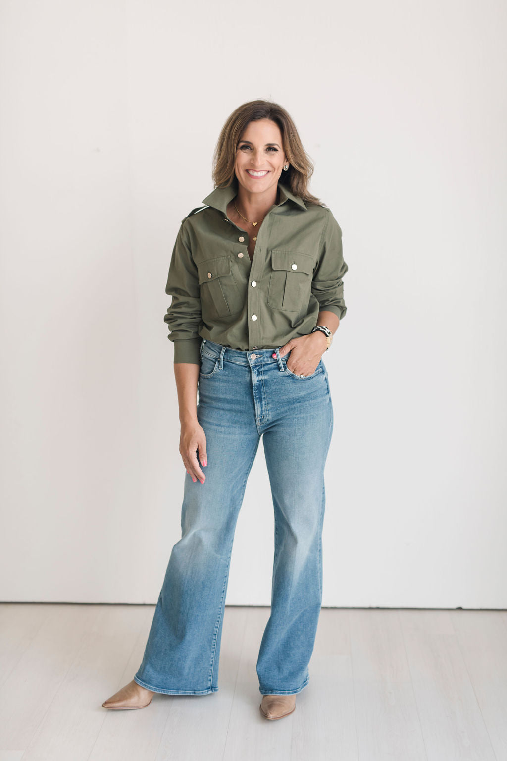 Women's olive green safari style button up shirt with gold buttons.