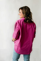 Pullover style short sleeve women's shirt with a short collar and buttons on the sleeves in berry pink.