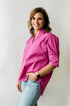 Pullover style short sleeve women's shirt with a short collar and buttons on the sleeves in berry pink.