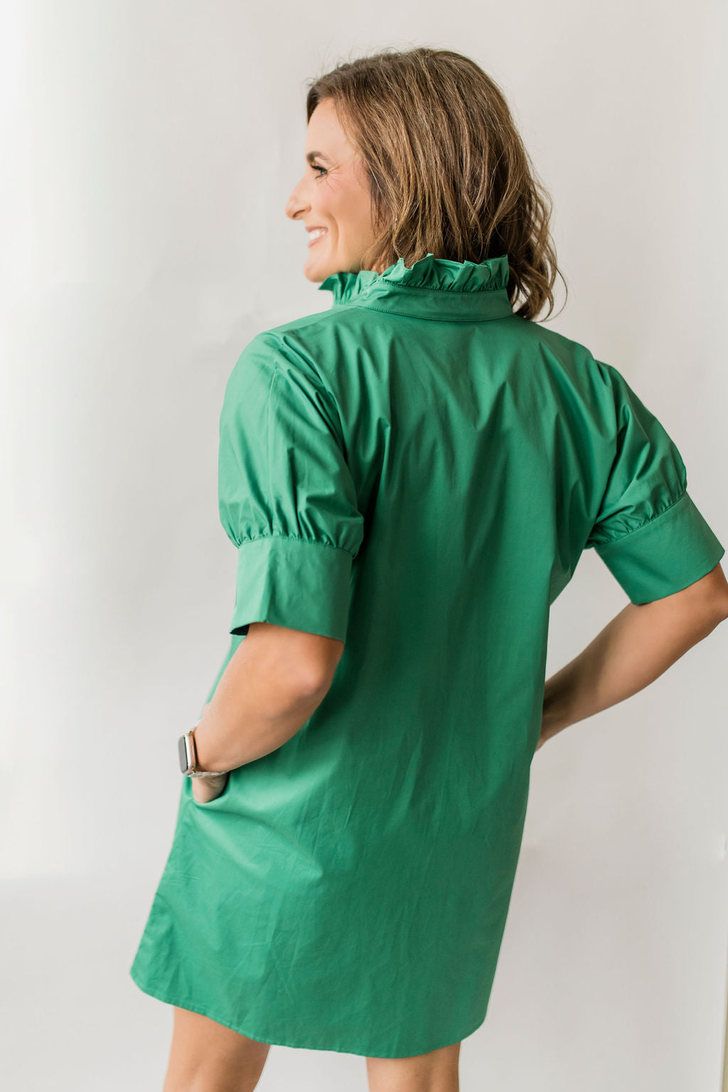 Women's short button down dress with short sleeves and a ruffle collar in green.