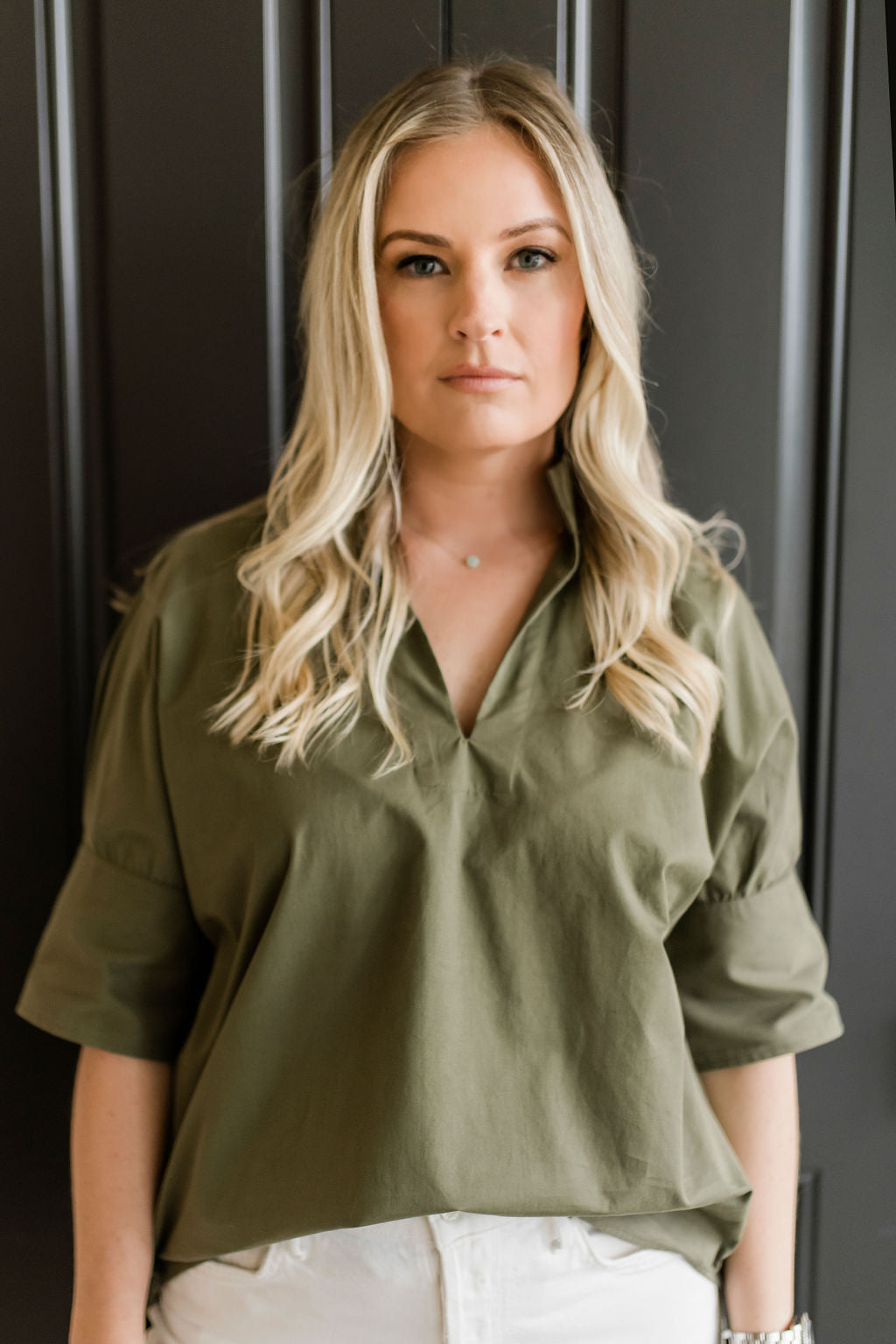 Pullover style short sleeve women's shirt with a short collar and buttons on the sleeves in olive green.