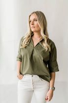 Pullover style short sleeve women's shirt with a short collar and buttons on the sleeves in olive green.