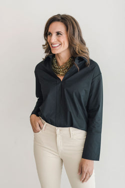 Black, crisp long sleeve shirt with a popped collar, pullover style.