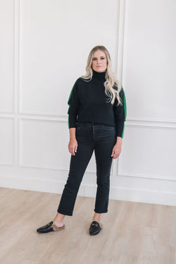 A cozy black and green color blocked turtleneck sweater.