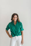 Green blouse with short sleeves and a ruffle collar.