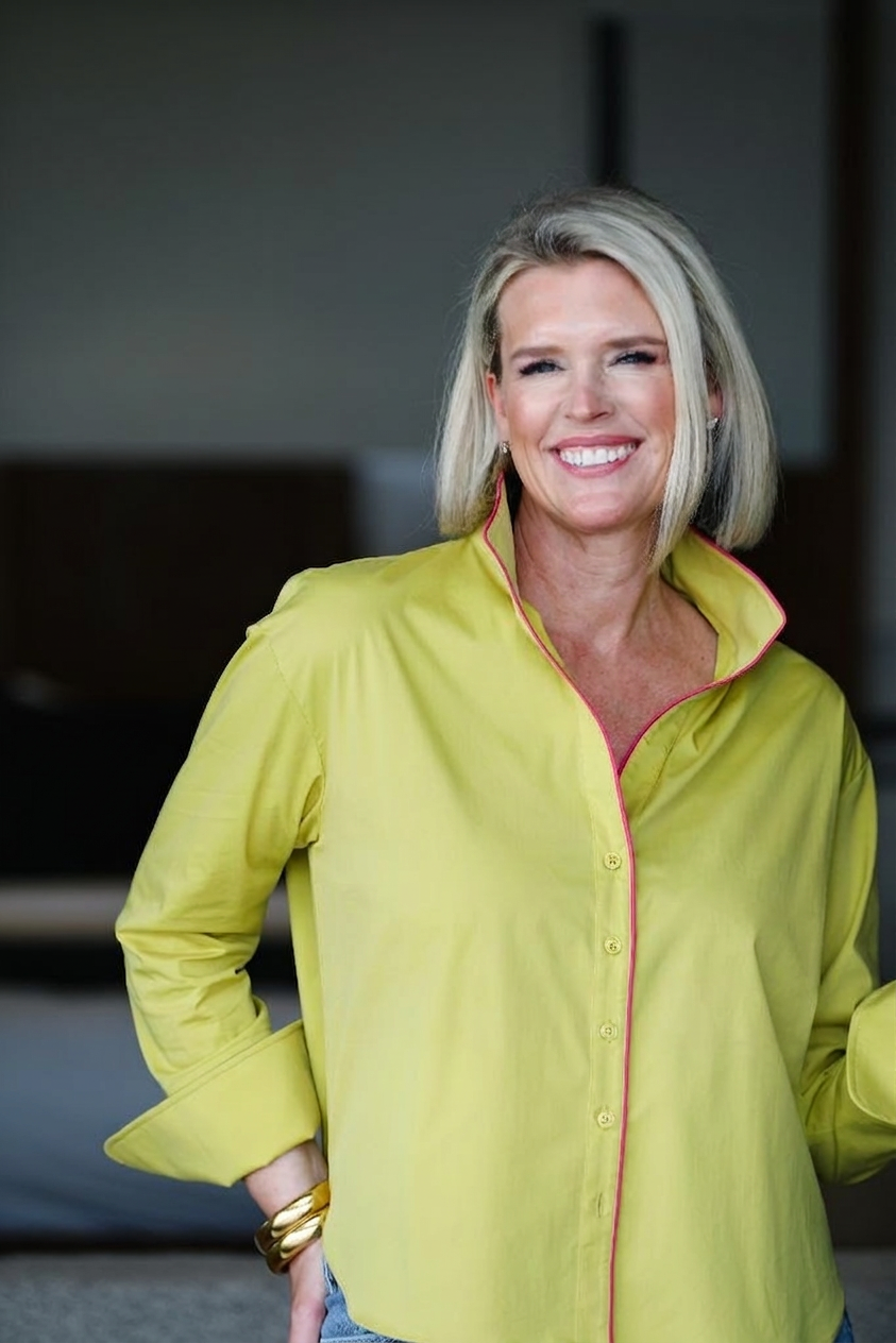 Woman wearing a bright yellow shirt with a pink trim indoors